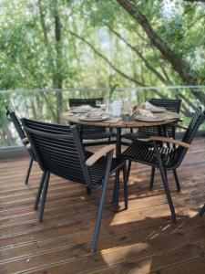 a wooden table with four chairs on a deck at Cabana Pescarului in Corabia