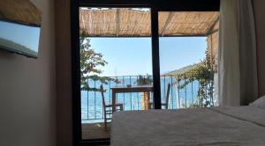 a bedroom with a large window with a view of the ocean at Çökertme Butik Otel in Çökertme