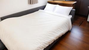 a large white bed in a hotel room at A forest guesthouse with barbecue facilities in Nikko