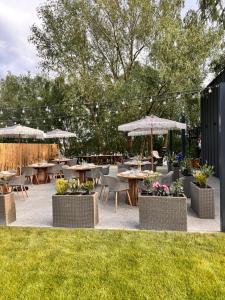 a patio with tables and chairs and umbrellas at Cabana Pescarului in Corabia