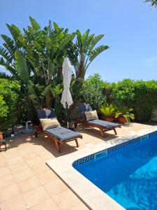 a pool with two chairs and an umbrella next to it at Casa Eleonora lifestyle Lodge in Lagos