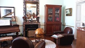 a living room with a piano and a chair at Chambres d'hôtes Le Griffon 1855 in Saint-Laurent-des-Autels