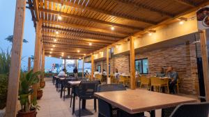 a restaurant with tables and chairs and a brick wall at Hotel Aloe Emira NKC in Nouakchott