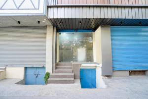 a building with two blue garage doors and stairs at Super Townhouse Krishna Nagar Metro Station in New Delhi +30 photos