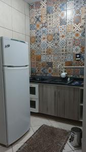 a kitchen with a white refrigerator and a tile wall at Casa Napolitana in Uruguaiana