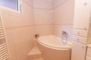 a white bathroom with a tub and a sink at House Roso in Makarska +32 photos