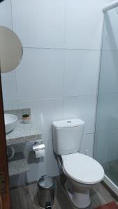 a white bathroom with a toilet and a sink at Casa Napolitana in Uruguaiana