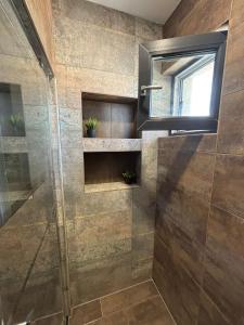 a shower with a glass door and a mirror at SeaEsta Studio in Agigea +21 photos