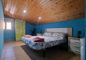a bedroom with a bed and a wooden ceiling at Areatza Home Mountain in Santiago de la Espada