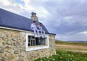two men sitting on the roof of a stone building at Areatza Home Mountain in Santiago de la Espada