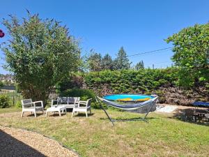 a boat sitting on the grass next to a table and chairs at Home Gãyatri in Angé