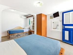 a small bedroom with two beds and a tv at Stavros Beachfront Domes by Booking Kottas in Perivolos