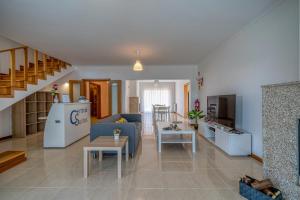 a living room with a blue couch and a kitchen at Central Suítes Arouca in Arouca