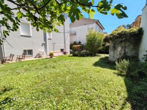 a yard with green grass and a white building at Il giardino di Ely in Senigallia