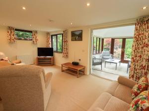 a living room with a couch and a television at Rowanberry Cottage in Grasmere