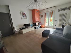 a living room with a couch and a tv at Il giardino di Ely in Senigallia
