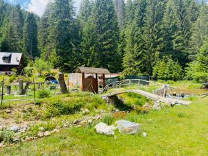a bridge over a river in a field with trees at Vikendica Avlija in Rožaje +7 photos