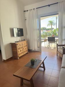 a living room with a couch and a tv and a table at Los Porches K28 in Playa del Ingles
