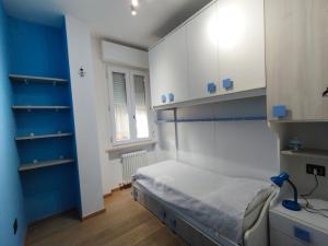 a bedroom with a bed with blue walls and shelves at Il giardino di Ely in Senigallia