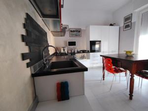 a kitchen with a sink and a table in it at Il giardino di Ely in Senigallia