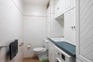 a white bathroom with a toilet and a sink at Central Freo Hideaway in Fremantle +8 photos