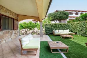 a patio with two chairs and a table and a table sidx sidx at Sa Murta Bianca Guesthouse Budoni in Budoni