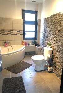 a bathroom with a tub and a toilet and a window at Maison de ville exceptionnelle in Carpentras +12 photos