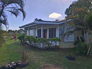 a house with a person riding a bike in front of it at DELAILOA ADVENTURES Homestay with Tom in Nadi