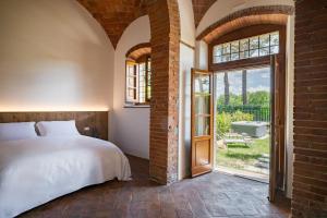 a bedroom with a bed and a large window at Tenuta dell'Oca Satolla in Pergine Valdarno
