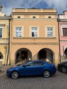 a blue car parked in front of a building at Apartmány u čalouníků in Litomyšl