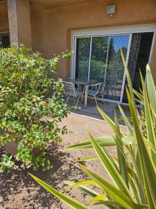 a patio with a table and chairs in front of a building at Cottage Fonsorbes RDC Maison in Fonsorbes