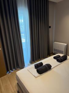 a bed with two black pillows on top of it at Dengu Luxury Apartments in Golem
