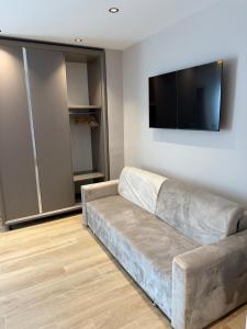 a living room with a couch and a flat screen tv at Dengu Luxury Apartments in Golem +1 photo