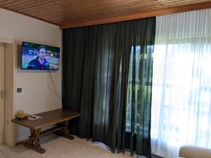 a room with a table and a window with a television at Monteur Budget Zimmer in Schöppenstedt