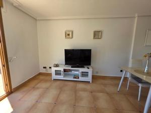 a living room with a tv on a white cabinet at Chalet Paradise of the Mediterranean in La Nucía