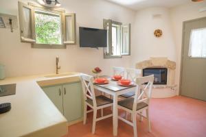 a kitchen with a table and chairs and a fireplace at Limni house in Kythira