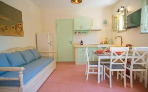 a living room with a couch and a table and a kitchen at Limni house in Kythira