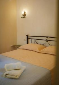 a bed with a white towel on top of it at Limni house in Kythira