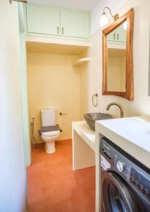 a bathroom with a toilet and a sink and a washing machine at Limni house in Kythira +14 photos
