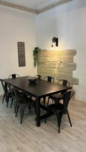 a black table and chairs in a room with a brick wall at Maison de ville exceptionnelle in Carpentras