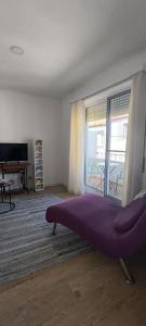 a room with a large purple bed in front of a window at Upstairs Home in Ponta Delgada