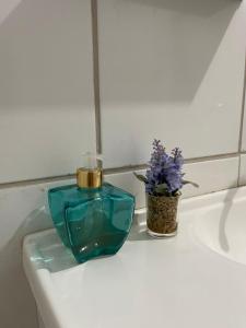a green perfume bottle sitting on top of a bathroom sink at Hotel Real Ipiranga in Três Marias +17 photos