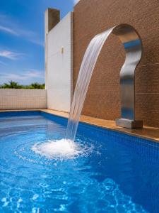 a water fountain in a swimming pool at Flat vista Mar -conforto e estilo em Ponta Negra-Natal in Natal
