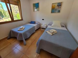 a bedroom with two beds and a window at Chalet Paradise of the Mediterranean in La Nucía +27 photos
