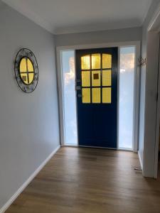 an empty room with a blue door and a clock at The Blue Wren in Blackheath