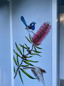 two birds perched on top of a pink flower at The Blue Wren in Blackheath