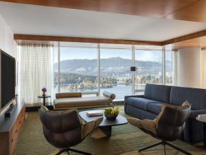 a living room with a blue couch and a large window at Fairmont Pacific Rim in Vancouver