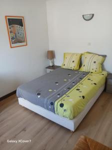 a bedroom with a bed with yellow and blue sheets at La grande escapade in Xertigny