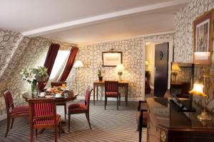 Una sala de estar con mesa y sillas y un comedor. en Hotel Résidence Des Arts - Saint-Germain, en París