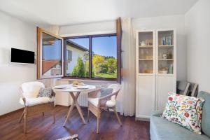 a living room with a table and chairs and a window at Ferienwohnung Krokus in Weiler-Simmerberg